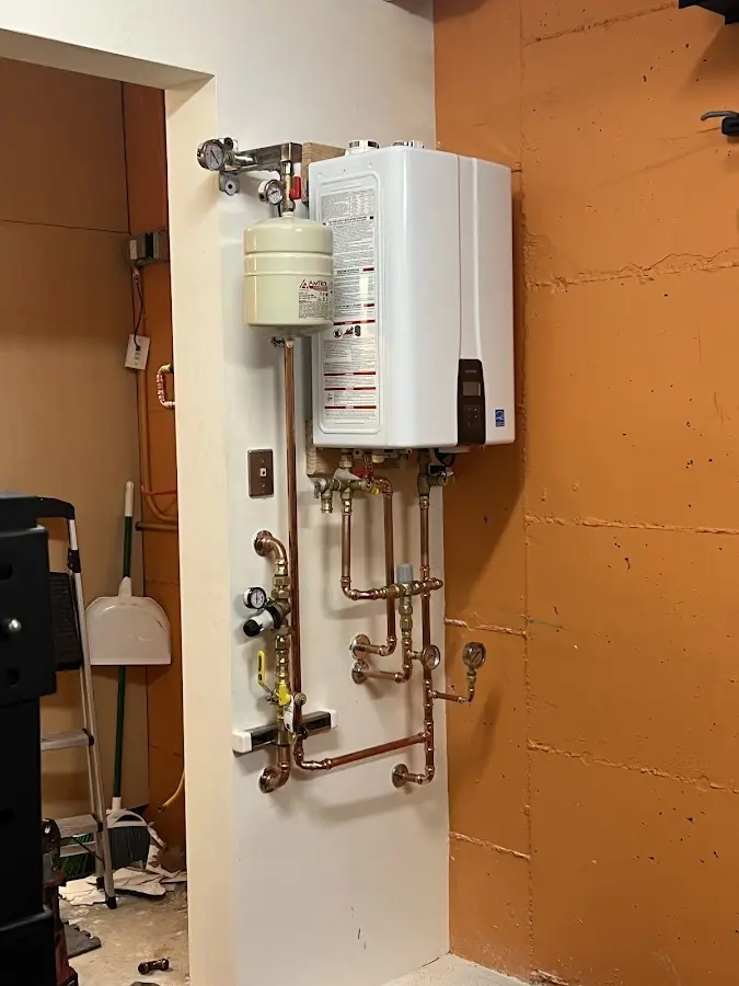 Plumbing technician inspecting water heater connections in Cheboygan